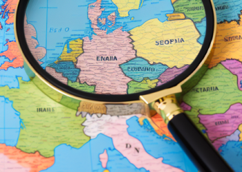 A magnifying glass placed on a world map, symbolic of detective work across European territories