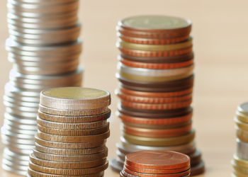 A pile of coins on a desk, symbolizing the accumulation of small earnings into a notable amount