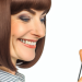 A woman smiling at her mobile phone, indicating the successful use of a cashback app